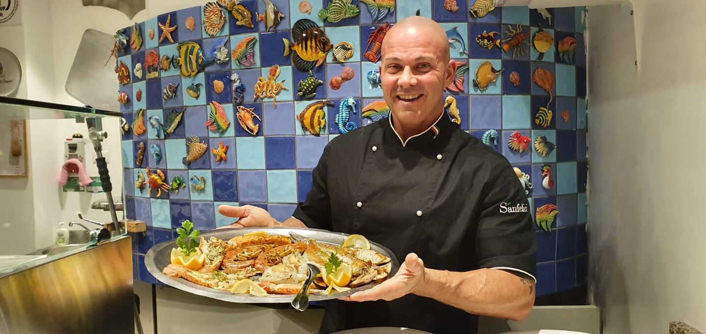 Lo chef presenta un piatto di mare