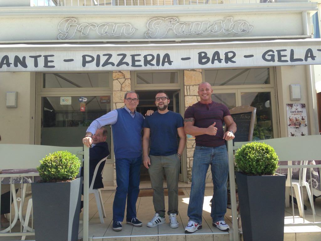 Der Eingang unter dem Schild „Gran Fausto“ und dem Schriftzug „ristorante · pizzeria · bar · gelateria“.