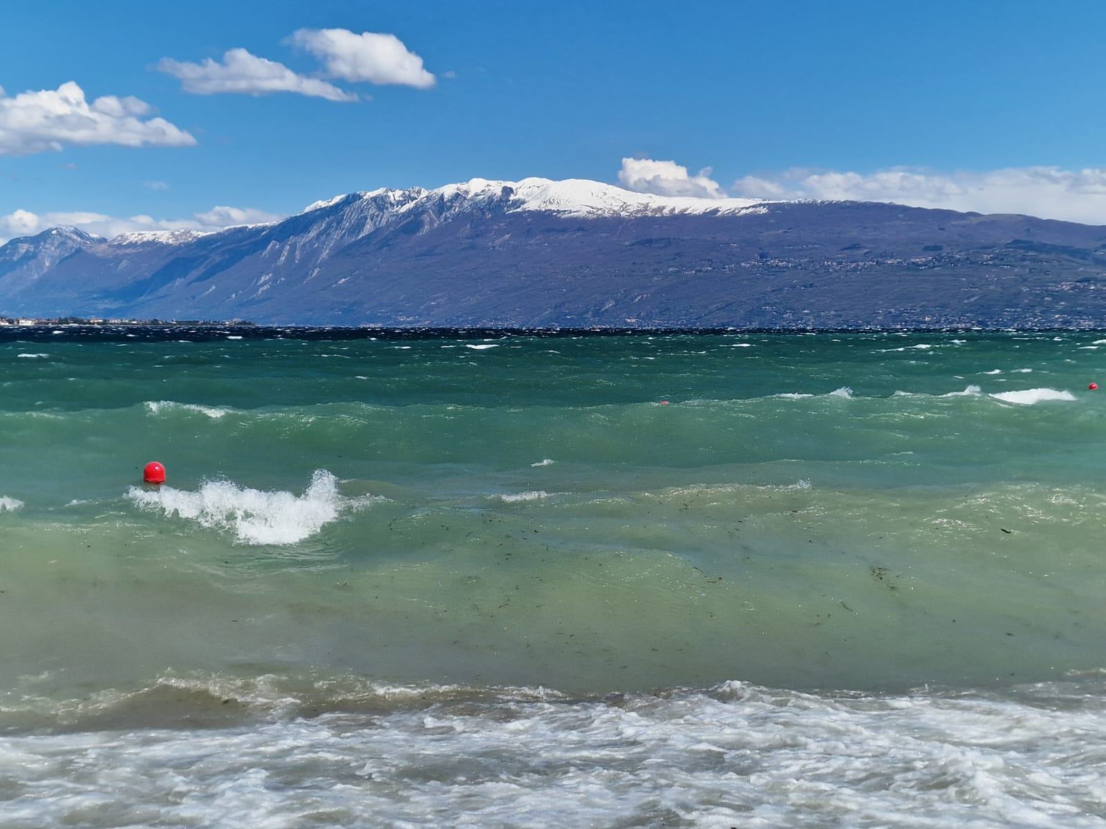 The lake towards the snow-capped mountains, on a windy day.