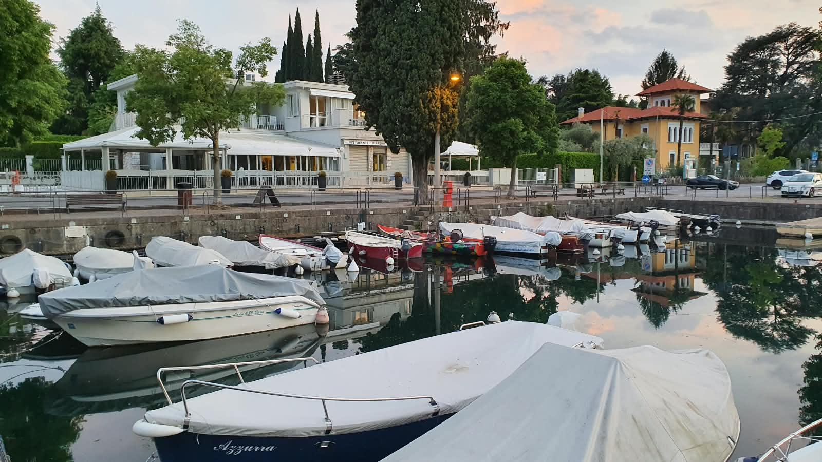 Der Hafen in der Dämmerung, das Schild „ristorante · pizzeria“ über der Terrasse.