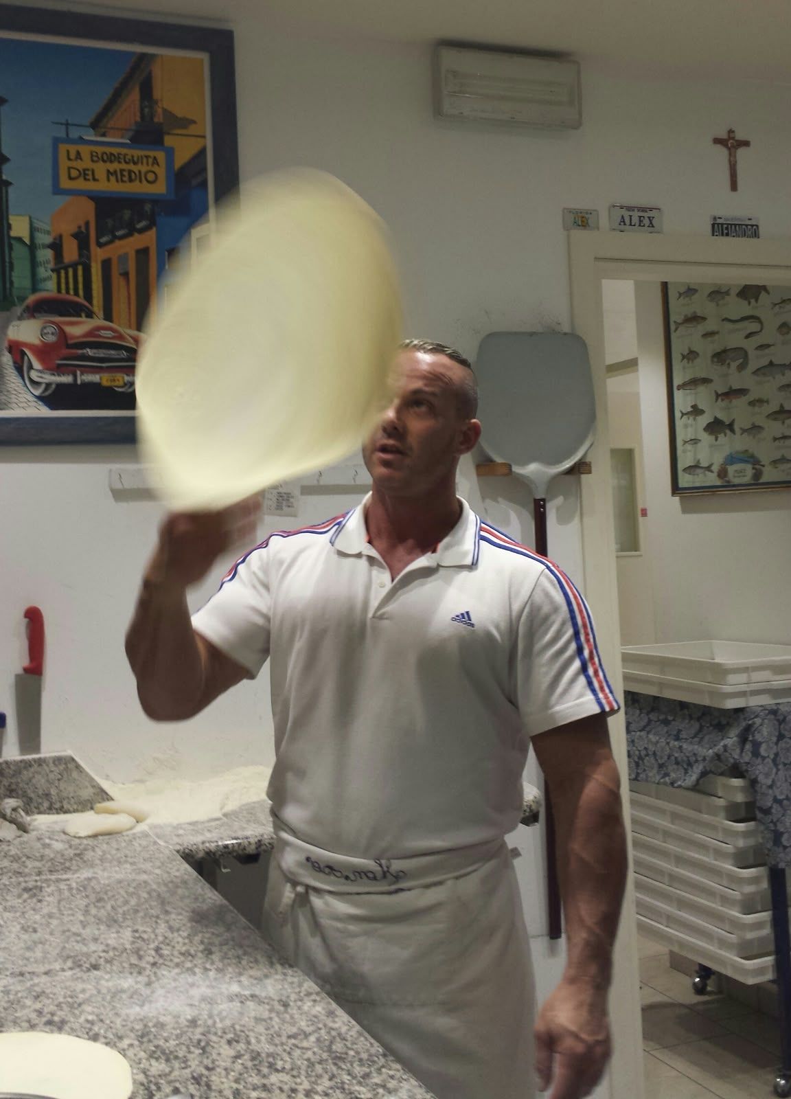 Der Pizzabäcker wirft den Teig in die Luft.