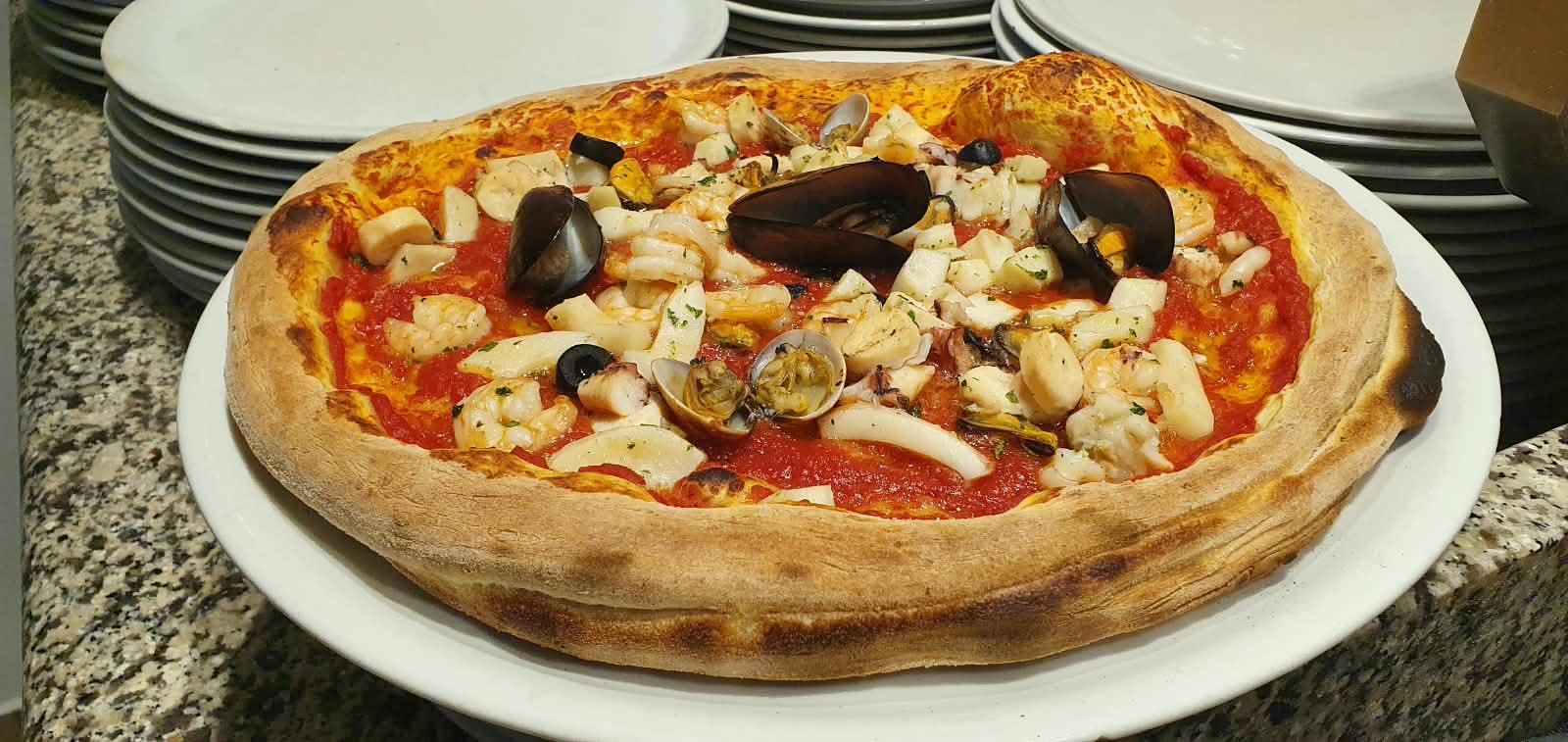 Eine Meeresfrüchte-Pizza mit Miesmuscheln, Venusmuscheln und Tintenfisch.